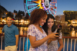 Image of 2 girls on their phone inside Disney California Adventure Park